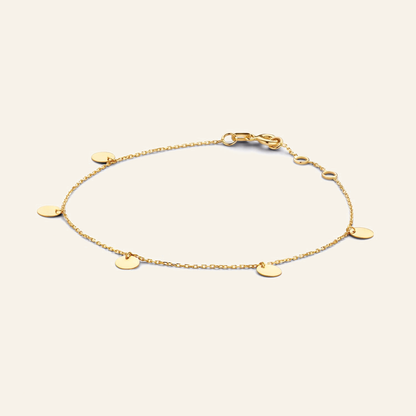 Jackie Amsterdam Discs bracelet in 14K yellow gold on light beige background