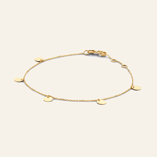 Jackie Amsterdam Discs bracelet in 14K yellow gold on light beige background
