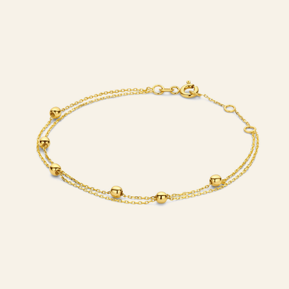Jackie Amsterdam Double Bubble Bracelet in 14K Yellow Gold on light beige background