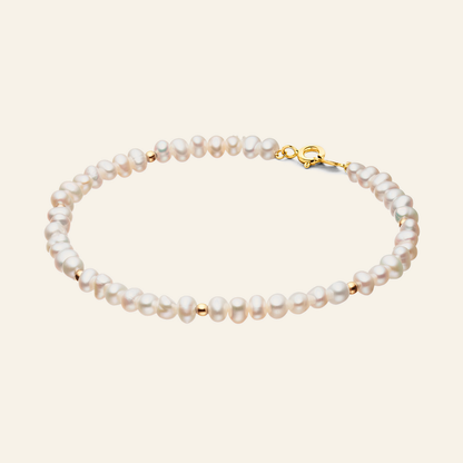 Jackie Amsterdam Pearl Potion Bracelet in 14K Yellow Gold on light beige background