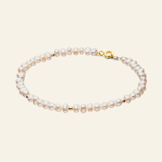 Jackie Amsterdam Pearl Potion Bracelet in 14K Yellow Gold on light beige background