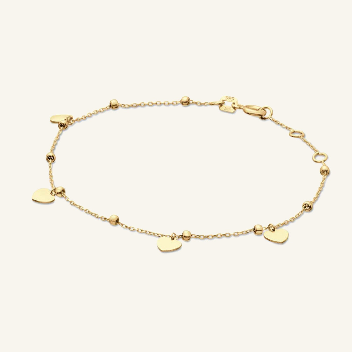 Jackie Amsterdam Corazon bracelet in 14K yellow gold on pale beige background