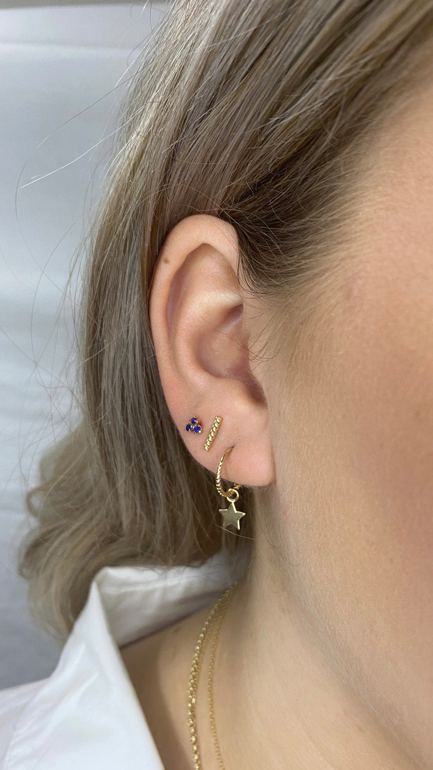 Triangle Sapphire Studs in 14K Yellow Gold worn on ear