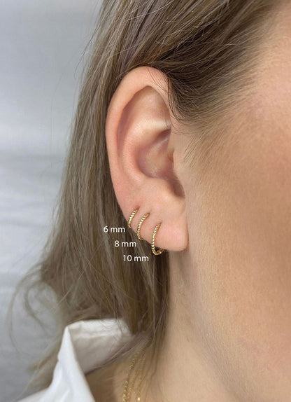 Jackie Twist Hoops in 14K Yellow Gold worn on ear