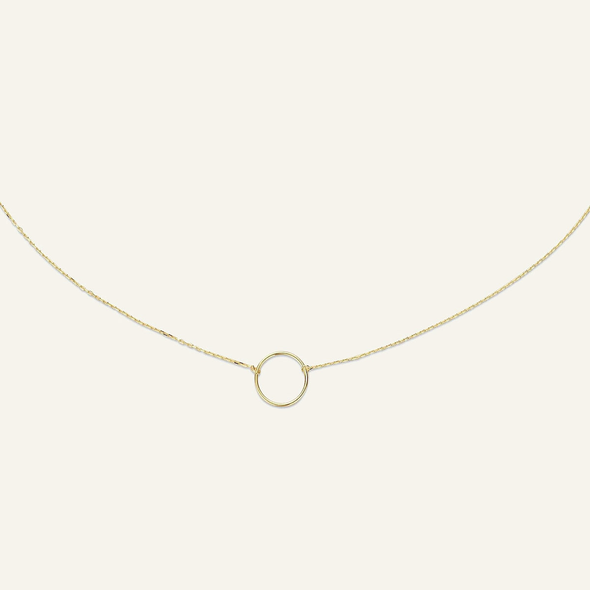 Jackie Amsterdam Circle Silhouette necklace in 14K yellow gold on pale beige background