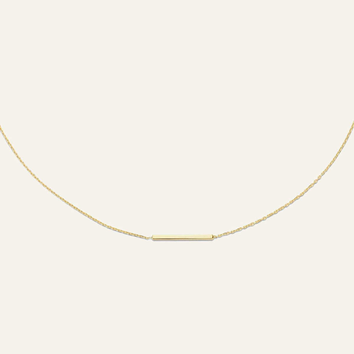 Jackie Amsterdam Bar necklace in 14K yellow gold on pale beige background