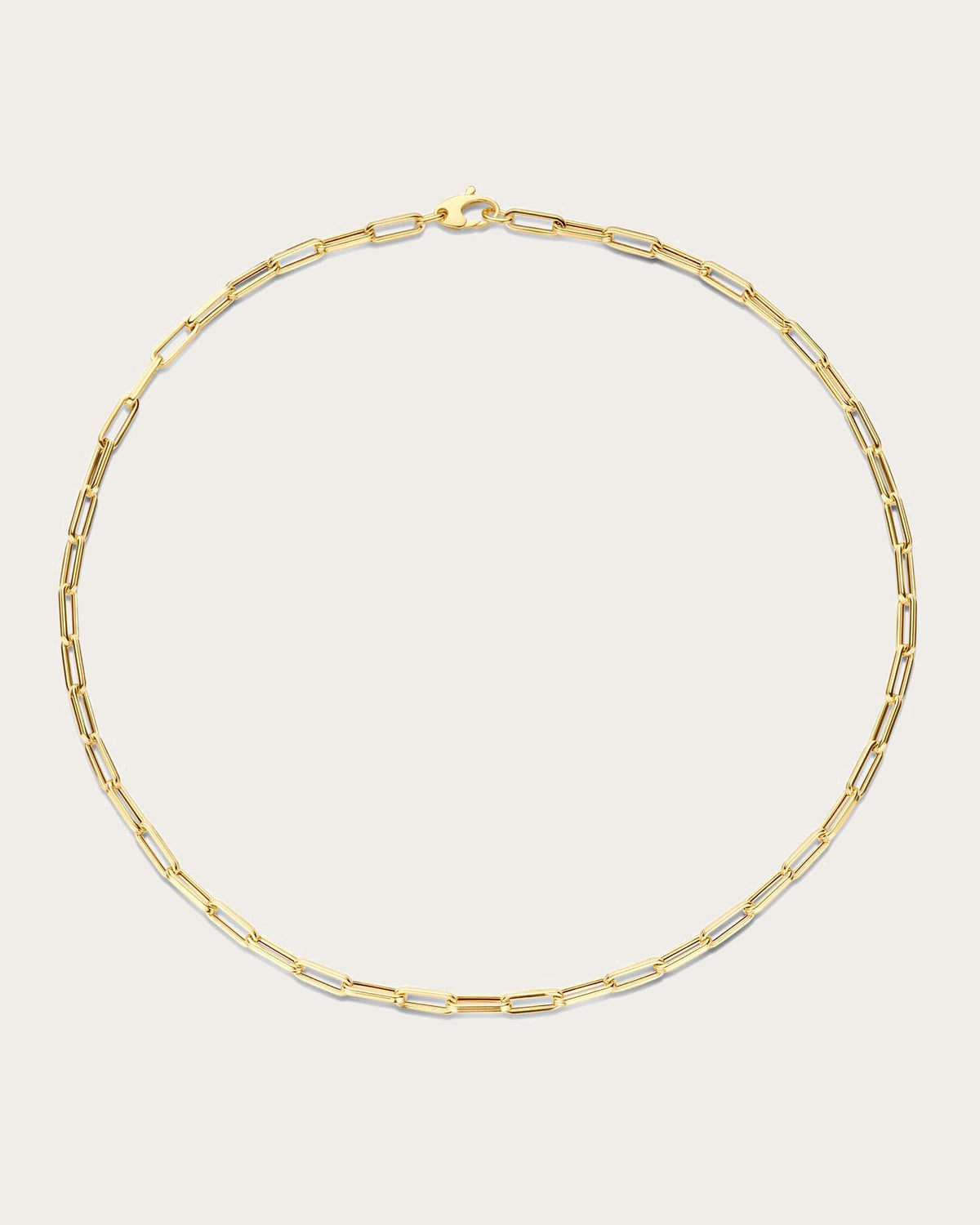 Jackie Amsterdam Elegant Boxlink necklace in 14K yellow gold on light beige background