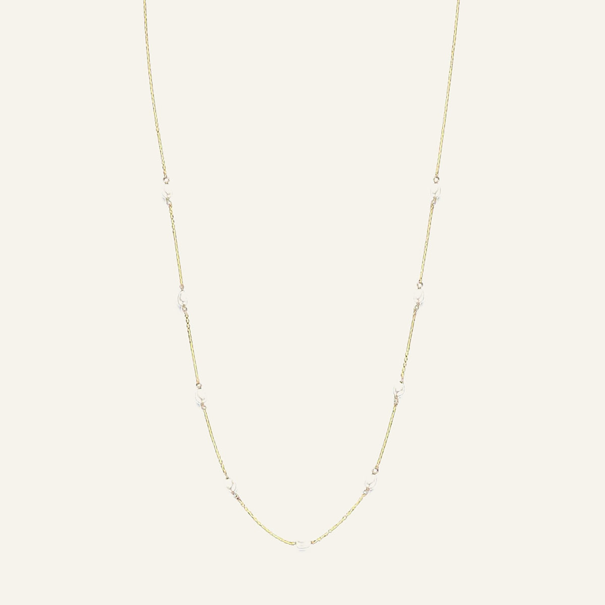 Jackie Amsterdam Pearls of Amalfi necklace in 14K yellow gold on pale beige background