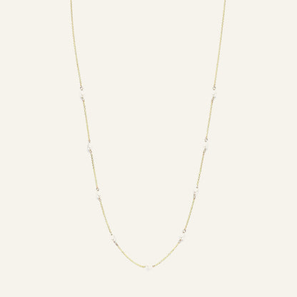 Jackie Amsterdam Pearls of Amalfi necklace in 14K yellow gold on pale beige background