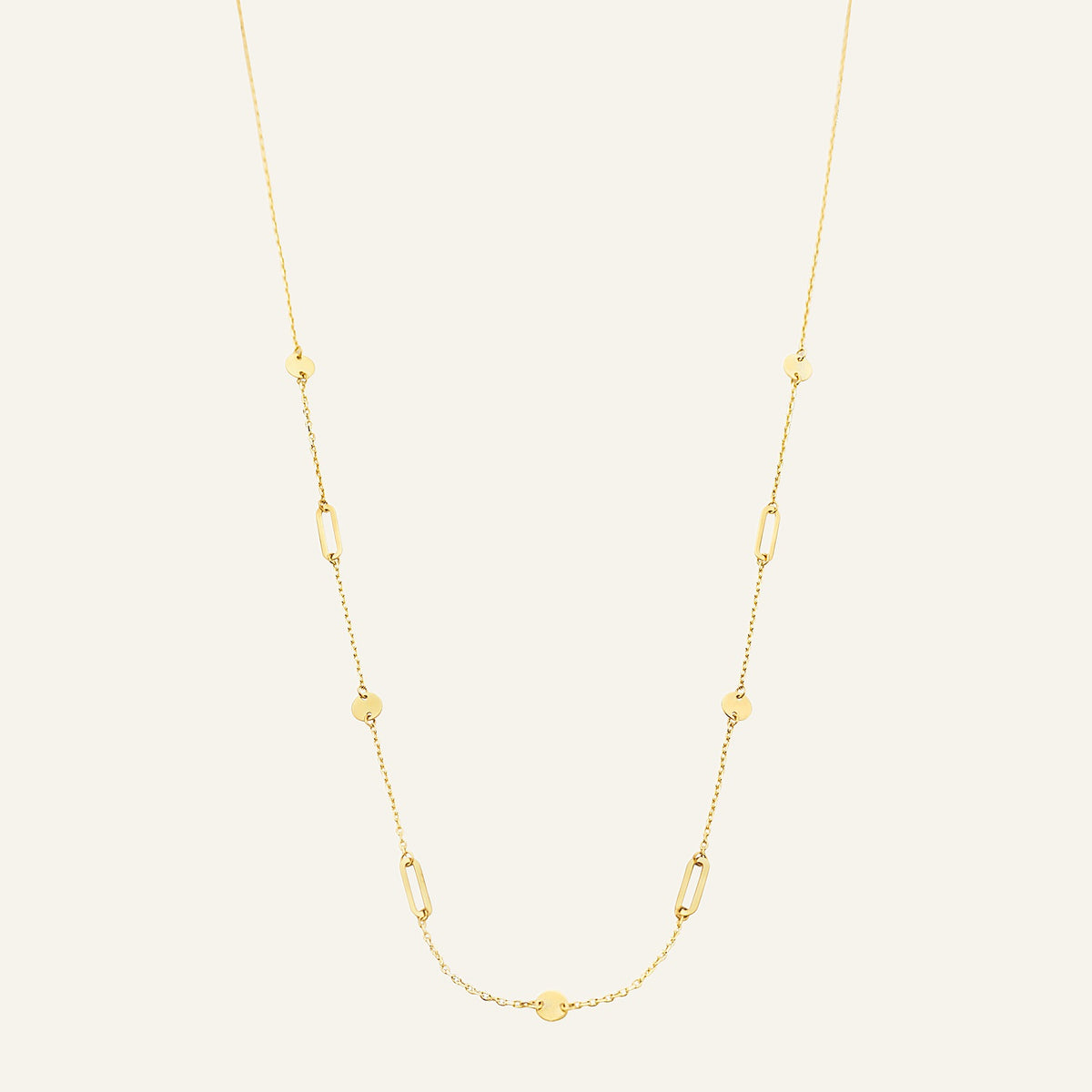 Jackie Amsterdam Beaux Arts necklace in 14K yellow gold on pale beige background