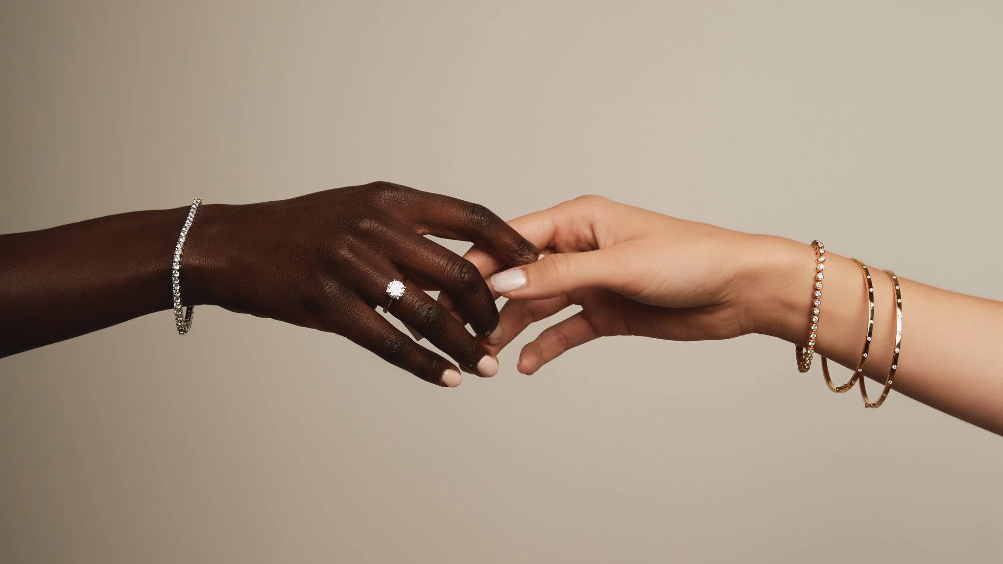Two hands reaching towards each other with a ring on a neutral background